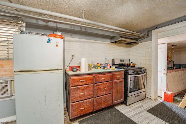 32 N Florida Ave, Atlantic City, NJ 08401 - kitchen with stainless steel range with gas stovetop, freestanding refrigerator, ventilation hood, a textured ceiling, and brown cabinets