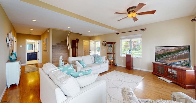 living area featuring stairs, wood finished floors, baseboards, a ceiling fan, and recessed lighting