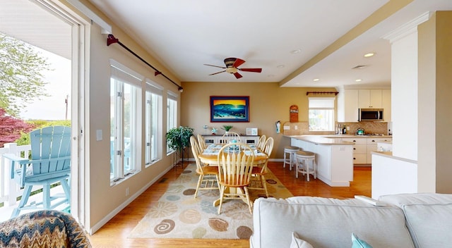 dining space with light wood finished floors, a ceiling fan, recessed lighting, and baseboards