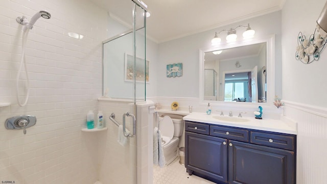 bathroom featuring a wainscoted wall, a stall shower, crown molding, vanity, and toilet
