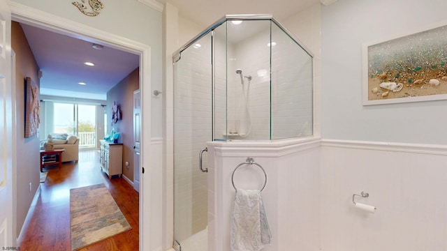 bathroom featuring wood finished floors, a stall shower, a wainscoted wall, and recessed lighting