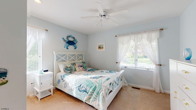 bedroom with light colored carpet, baseboards, and ceiling fan
