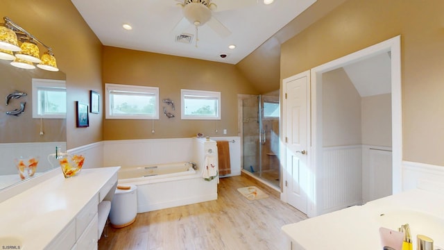full bath featuring a wainscoted wall, a shower stall, vanity, a bath, and wood finished floors