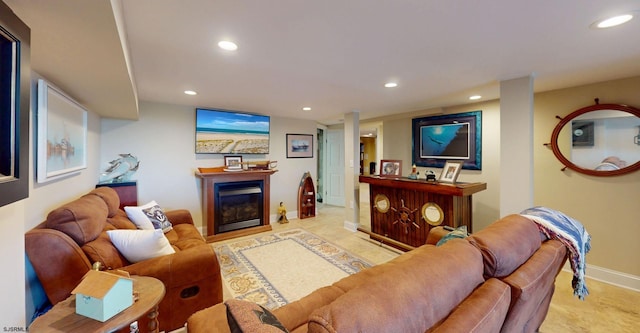 living area with recessed lighting, baseboards, and a glass covered fireplace