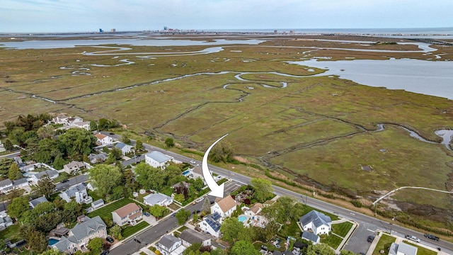 aerial view of property's location with a large body of water and nearby suburban area
