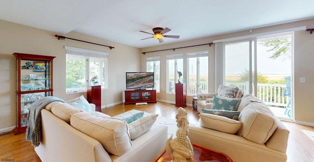 living room with healthy amount of natural light, light wood finished floors, and baseboards