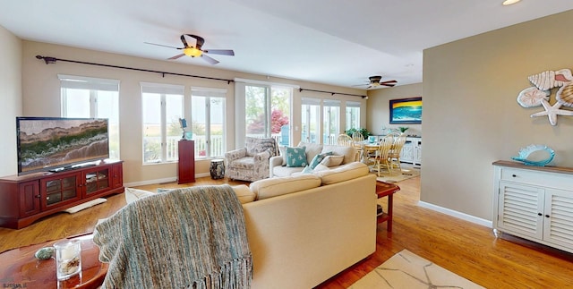living area featuring a ceiling fan, wood finished floors, and baseboards