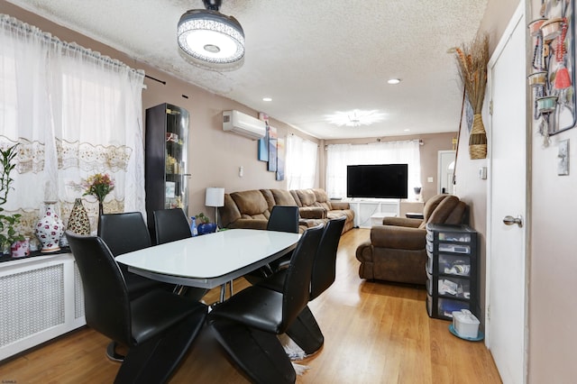 15 N Marion Ave, Ventnor, NJ 08406 - dining space featuring radiator heating unit, a wall unit AC, light wood-style flooring, a textured ceiling, and recessed lighting