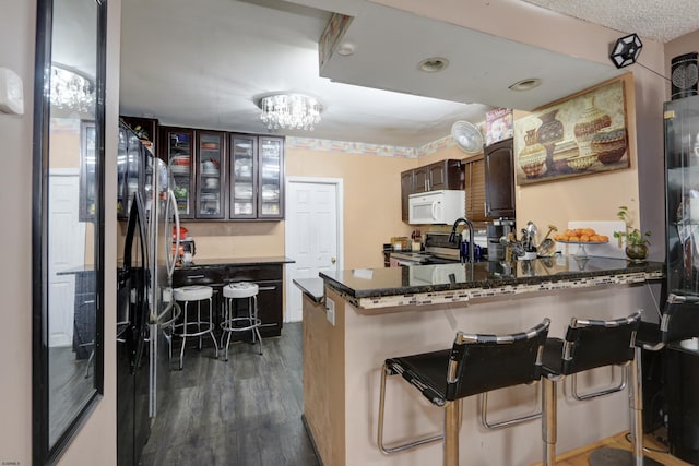 15 N Marion Ave, Ventnor, NJ 08406 - kitchen with white microwave, electric stove, a kitchen bar, a peninsula, and dark wood finished floors