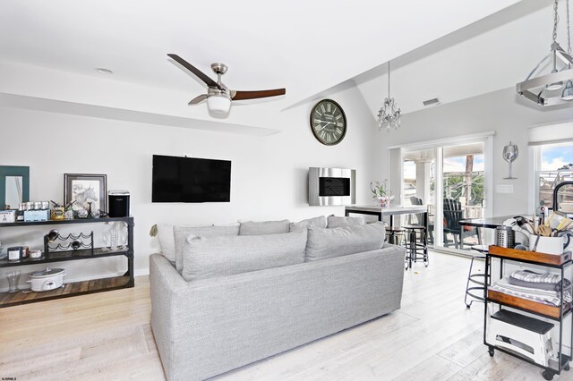 9315 Ventnor Ave, Margate, NJ 08402 - living room featuring light wood-type flooring, ceiling fan, vaulted ceiling, and a chandelier