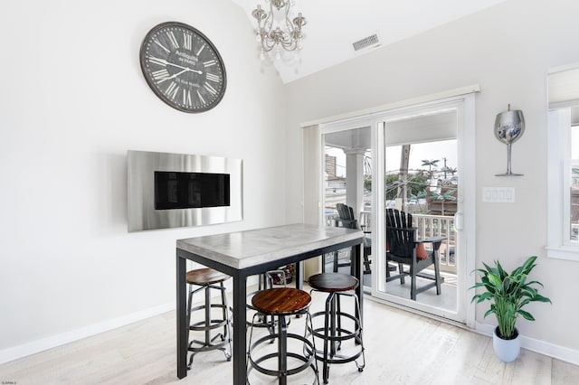9315 Ventnor Ave, Margate, NJ 08402 - dining room with a chandelier, light wood-style floors, baseboards, and vaulted ceiling