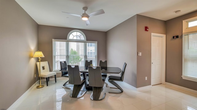 dining space featuring a ceiling fan, baseboards, light tile patterned floors, and a desk