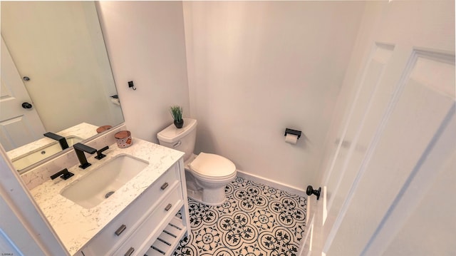 half bath featuring toilet, vanity, and baseboards