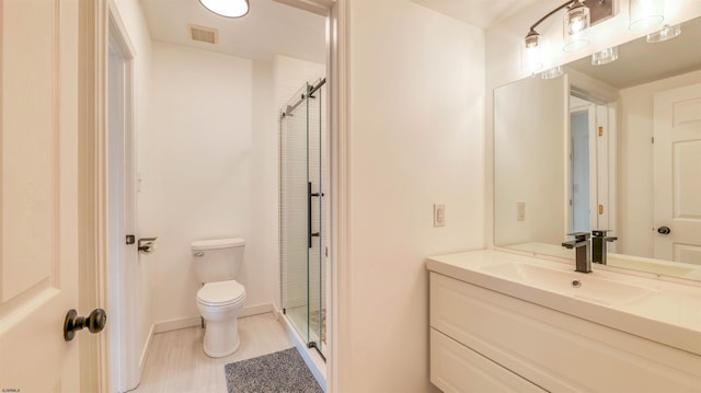 full bathroom with a stall shower, toilet, vanity, and baseboards