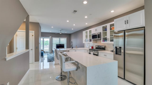 kitchen with stainless steel appliances, a sink, a peninsula, recessed lighting, and ceiling fan