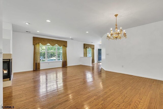 317 Southmoor Dr, Galloway Township, NJ 08205 - unfurnished living room featuring a chandelier, wood finished floors, a glass covered fireplace, recessed lighting, and baseboards