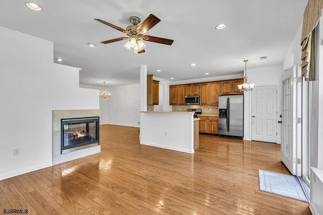 317 Southmoor Dr, Galloway Township, NJ 08205 - kitchen with stainless steel appliances, a chandelier, brown cabinets, light countertops, and recessed lighting