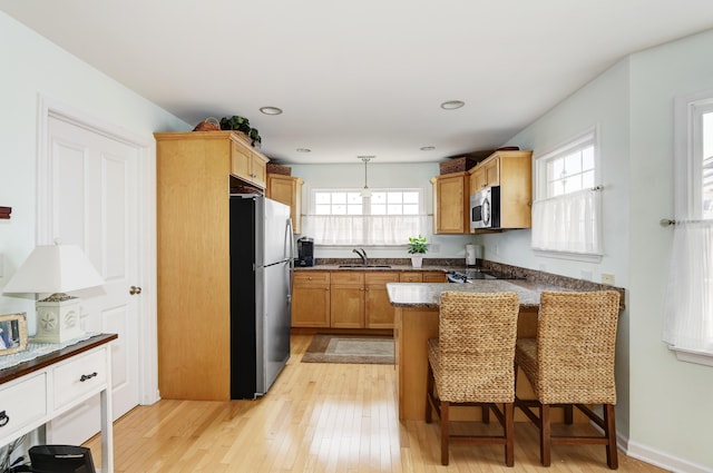 818 Aldrich Rd Fl 2Nd, Ocean City, NJ 08226 - kitchen with appliances with stainless steel finishes, a sink, a peninsula, a kitchen bar, and light wood-type flooring