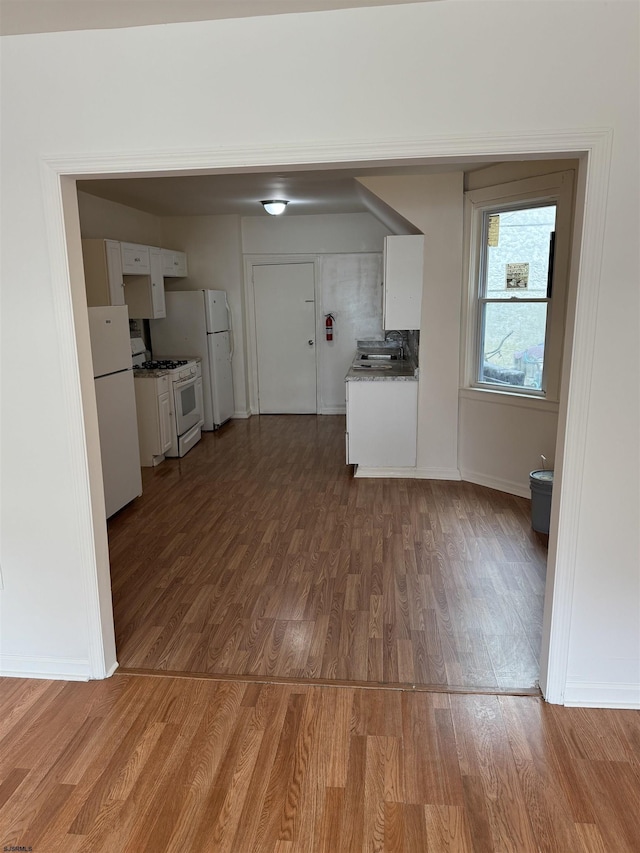 2015 Grant Ave, Atlantic City, NJ 08401 - kitchen featuring white appliances, wood finished floors, white cabinetry, and a sink