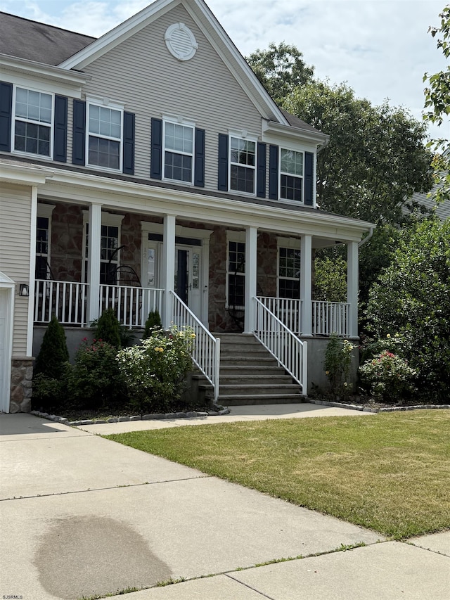 127 Rockport, Egg Harbor Township, NJ 08234 - view of front of house featuring stone siding, covered porch, and a front yard