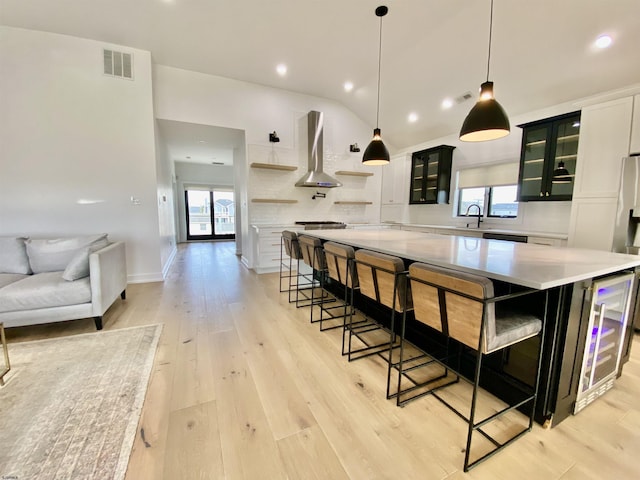 116 Bayshore Ave, Brigantine, NJ 08203 - kitchen with wall chimney range hood, plenty of natural light, light countertops, vaulted ceiling, and wine cooler