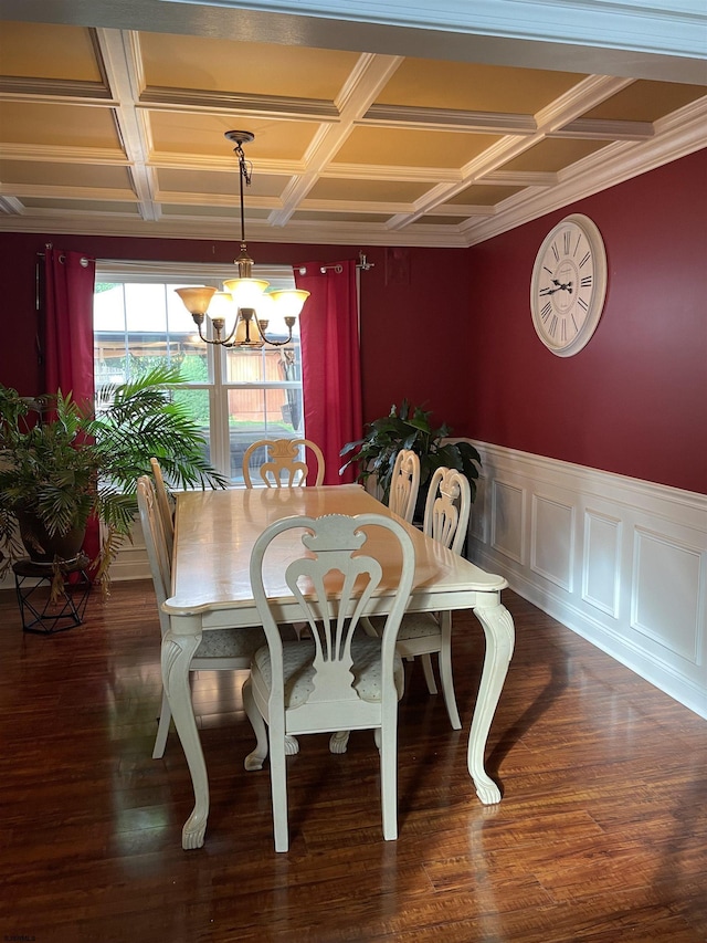 dining area featuring coffered ceiling, a chandelier, wood finished floors, and a wainscoted wall