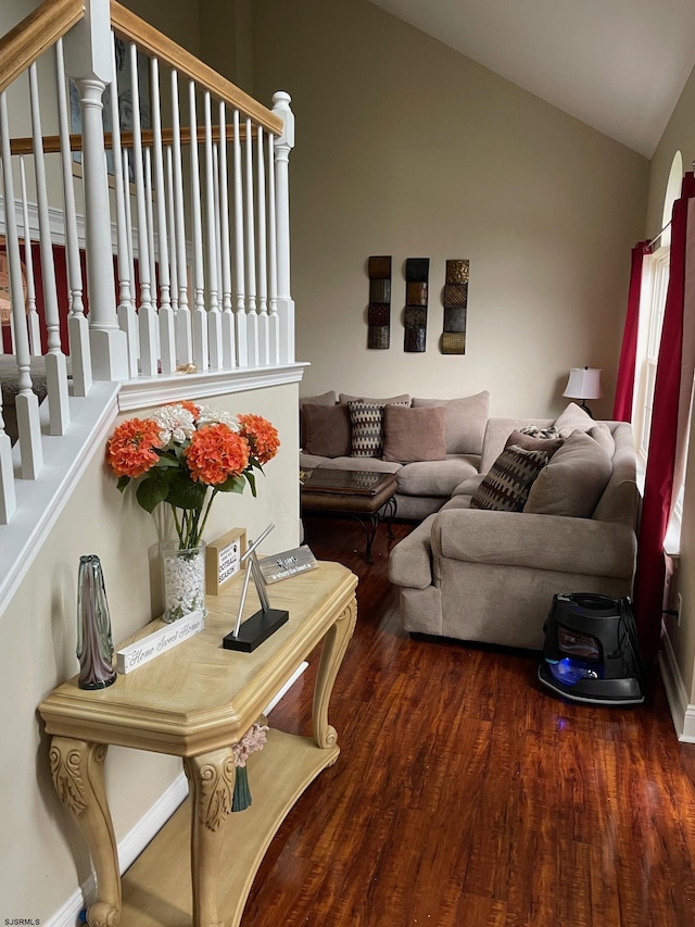 living room featuring lofted ceiling, wood finished floors, and stairway