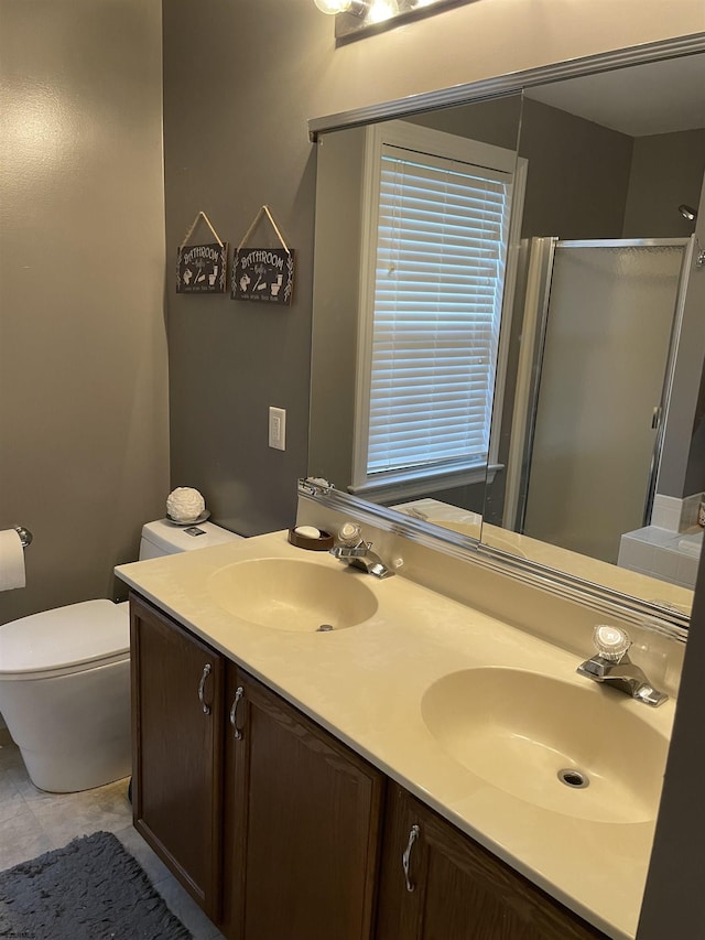 bathroom featuring a stall shower, double vanity, toilet, and tile patterned flooring