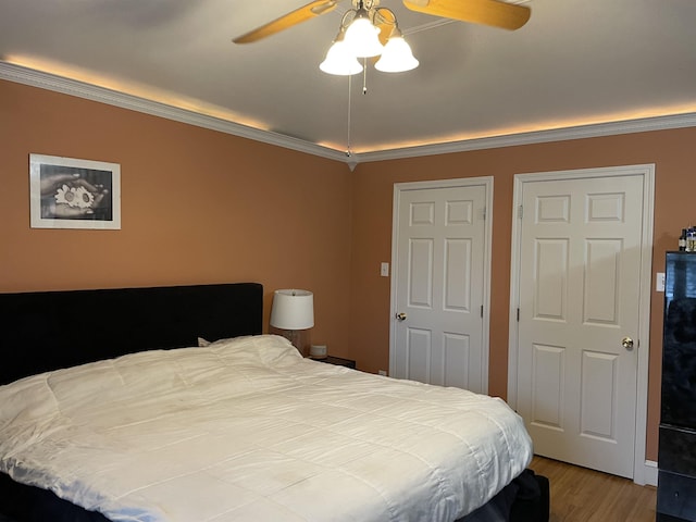 bedroom featuring wood finished floors, crown molding, and a ceiling fan