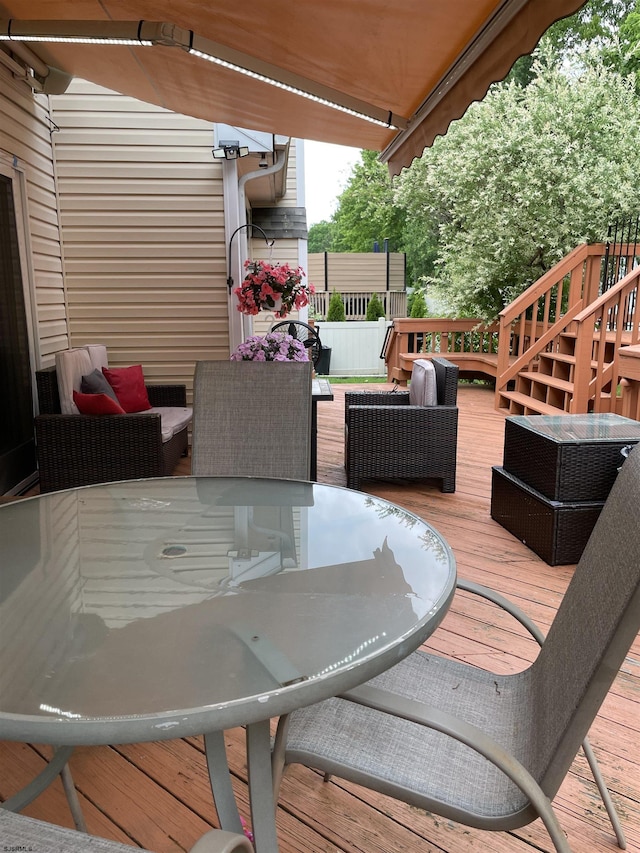 deck with stairway, an outdoor living space, and outdoor dining space