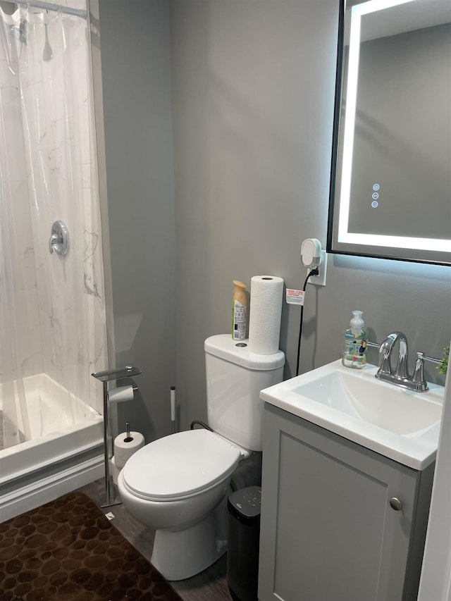 bathroom featuring curtained shower, toilet, and vanity