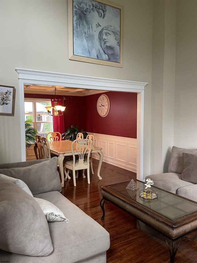 living room featuring wood finished floors, a chandelier, and a wainscoted wall