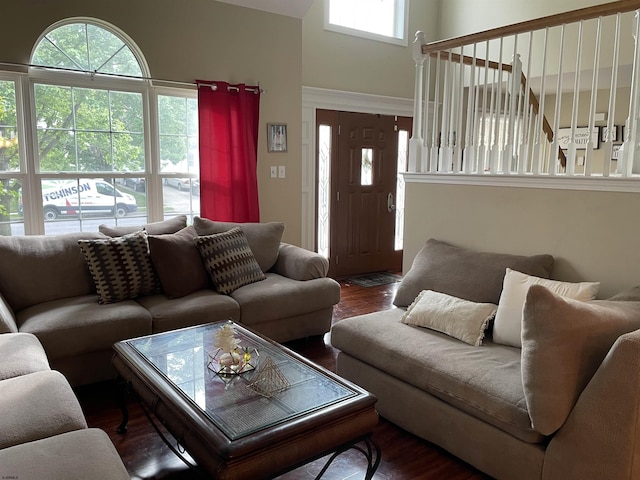 living room with plenty of natural light, wood finished floors, and a high ceiling