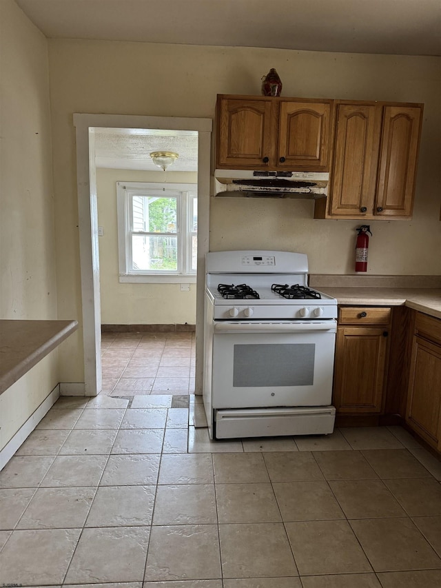 224 Linden Ave, Pleasantville, NJ 08232 - kitchen featuring gas range gas stove, under cabinet range hood, light tile patterned floors, and brown cabinets