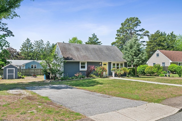 view of front facade featuring a storage unit, an outbuilding, and a shingled roof