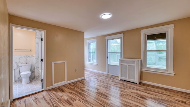 25 N Aberdeen Pl, Atlantic City, NJ 08401 - unfurnished room featuring radiator heating unit, light wood-style flooring, baseboards, and tile walls