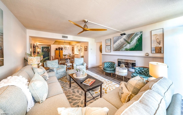 500 Bay Ave Unit 406S, Ocean City, NJ 08226 - living area with wood finished floors, a ceiling fan, a textured ceiling, a chandelier, and a fireplace