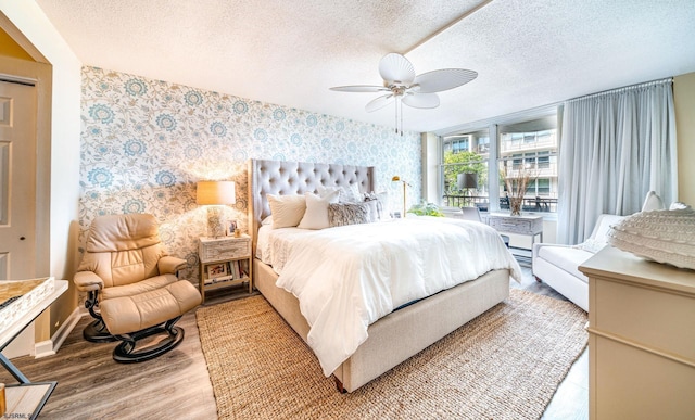 500 Bay Ave Unit 406S, Ocean City, NJ 08226 - bedroom featuring wallpapered walls, wood finished floors, a textured ceiling, an accent wall, and baseboards