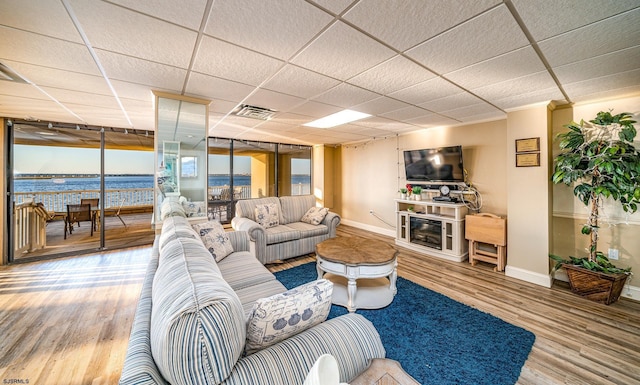 500 Bay Ave Unit 406S, Ocean City, NJ 08226 - living room with wood finished floors, baseboards, a paneled ceiling, a glass covered fireplace, and a water view