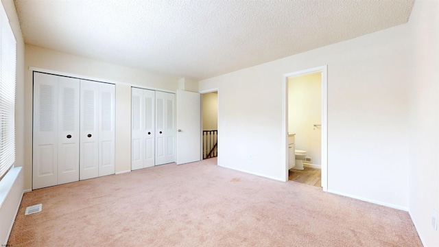 156 Rumson Dr Unit 156, Galloway Township, NJ 08205 - unfurnished bedroom with carpet flooring, two closets, ensuite bath, a textured ceiling, and baseboards