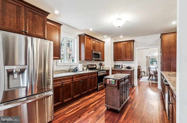 922 Central Ave, Hammonton, NJ 08037 - kitchen featuring appliances with stainless steel finishes, dark wood-style floors, a sink, light stone countertops, and a center island