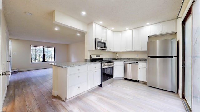 214 Mattix Run Unit 214, Galloway Township, NJ 08205 - kitchen featuring stainless steel appliances, light stone counters, light wood-style floors, recessed lighting, and a peninsula