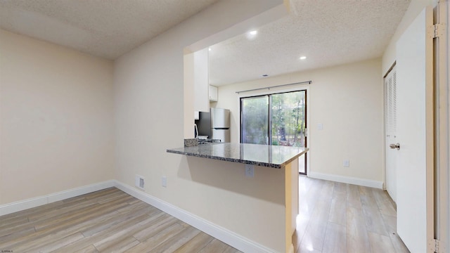 214 Mattix Run Unit 214, Galloway Township, NJ 08205 - kitchen with freestanding refrigerator, light wood-type flooring, white cabinets, a textured ceiling, and recessed lighting