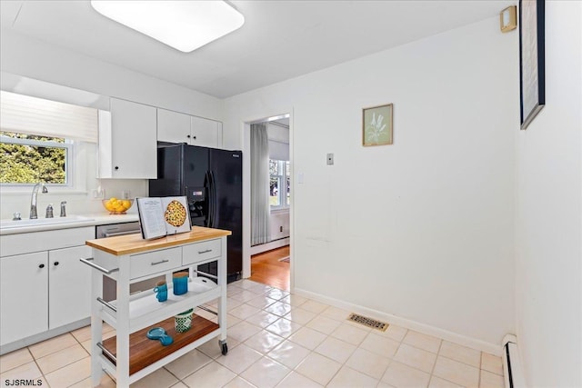 411 N Douglas Ave, Margate, NJ 08402 - kitchen with black refrigerator with ice dispenser, a sink, white cabinetry, and butcher block countertops