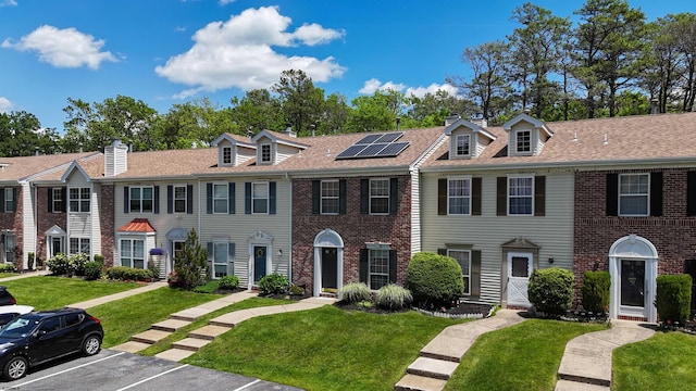 11 Cherokee Dr Unit 206, Galloway Township, NJ 08205 - townhome / multi-family property with roof mounted solar panels, a front lawn, uncovered parking, brick siding, and a chimney