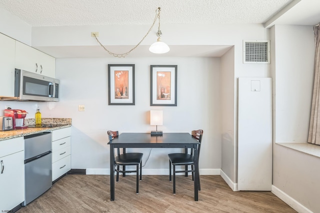 1515 Boardwalk Unit 1004, Atlantic City, NJ 08401 - dining area featuring light wood-type flooring, a textured ceiling, and baseboards
