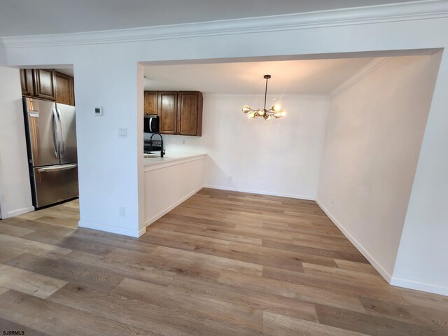 159 Heather Croft Unit 159, Egg Harbor Township, NJ 08234 - unfurnished dining area featuring a chandelier, light wood-type flooring, baseboards, and crown molding