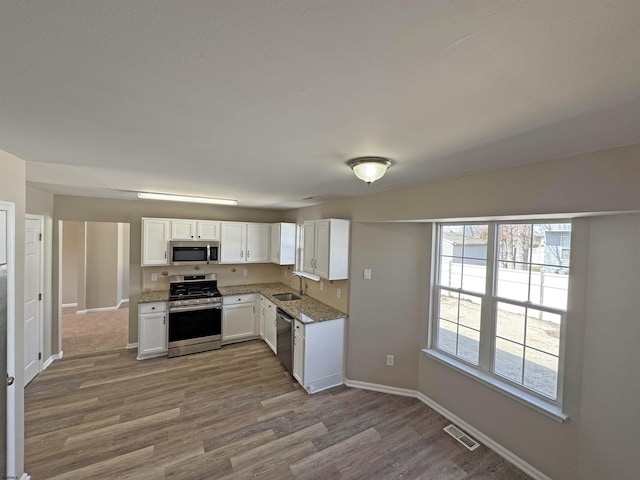 7 Nevis Dr, Egg Harbor Township, NJ 08234 - kitchen with stainless steel appliances, a sink, wood finished floors, white cabinets, and baseboards