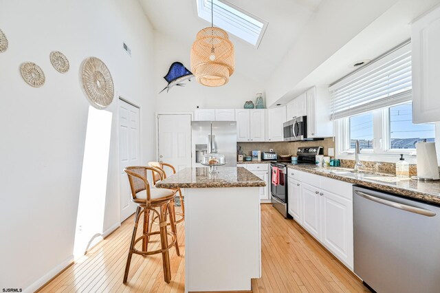 289 40th St Unit B, Brigantine, NJ 08203 - kitchen with appliances with stainless steel finishes, a skylight, white cabinetry, a sink, and high vaulted ceiling