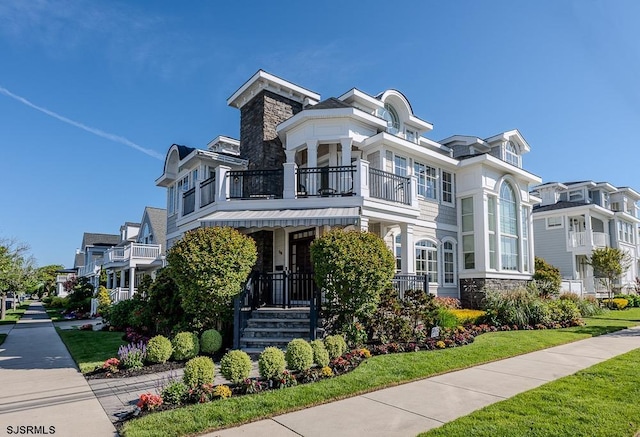 25 S Union Ave, Margate, NJ 08402 - view of front facade with a balcony, stone siding, and a front lawn